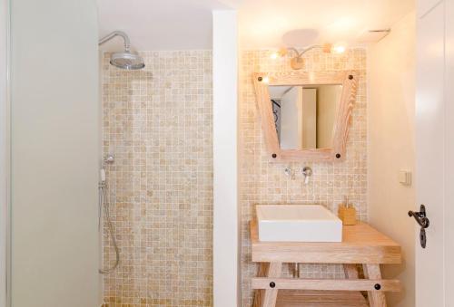 a bathroom with a sink and a mirror at Tholos Deluxe House in Astypalaia