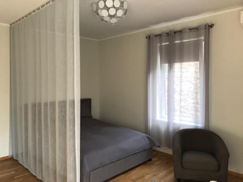 a bedroom with a bed and a chair and a window at Apartment in Kalamaja in Tallinn