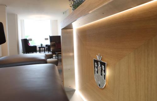 an office lobby with a wall clock on a wooden wall at Hotel Brunnenhaus Schloss Landau in Bad Arolsen