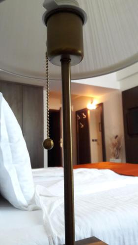 a bedroom with a bed with white sheets at Семеен хотел Анна-Кристина in Vidin