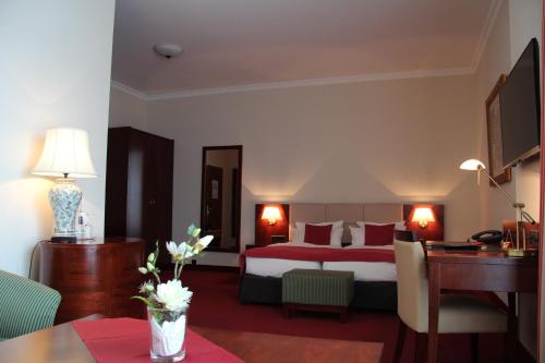 a hotel room with a bed and a desk at Hotel Amaris Bremerhaven in Bremerhaven