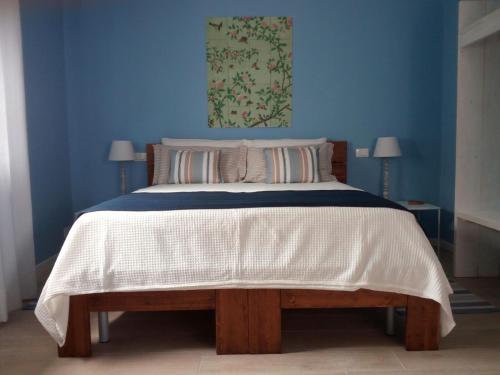 ein blaues Schlafzimmer mit einem Bett mit einer weißen Bettdecke in der Unterkunft Pan di Zucchero in Cittadella