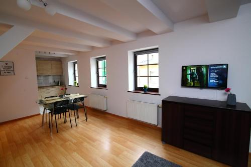 Una sala de estar con una mesa y sillas y un televisor. en Apartamenty Szabla Bydgoszcz 1, en Bydgoszcz