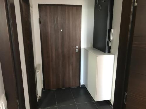 a wooden door in a room with a television at Apartment NM Bjelašnica in Bjelašnica