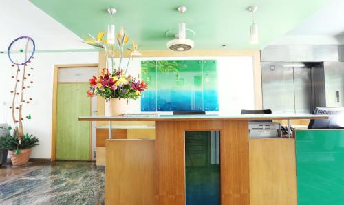 una cucina con un bancone con un vaso di fiori di Treebo Edha Suites Koramangala a Bangalore