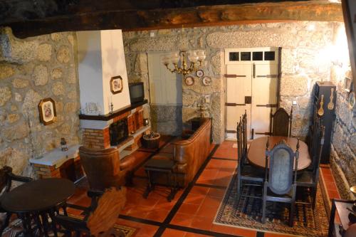 a living room with stone walls and a table and chairs at Casa da Ponte do Arrocho in Loriga