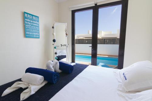 1 dormitorio con cama y piscina en Villa Carmen- Lanzarote, en Playa Blanca