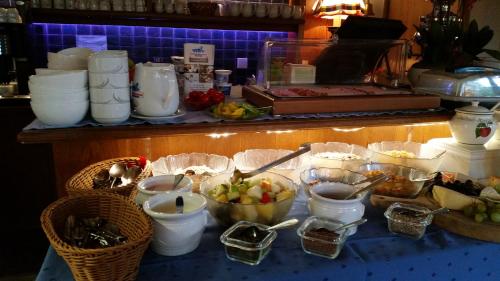 a buffet with bowls of fruit and other food on a table at Sportpension Christina by PiaundDirk in Fügen