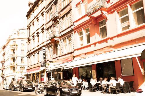 a group of people sitting outside of a restaurant at Main Hotel Frankfurt City in Frankfurt/Main