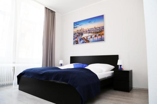 a bedroom with a large bed with a blue blanket at Main Hotel Frankfurt City in Frankfurt/Main