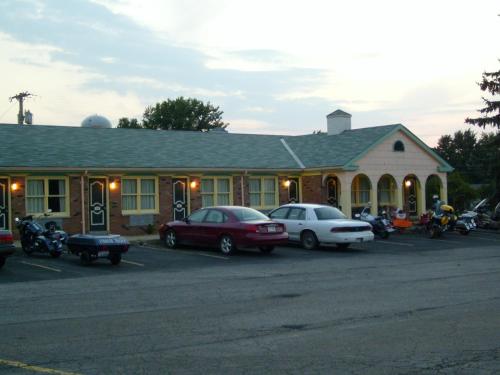 un bâtiment avec des voitures garées dans un parking dans l'établissement Relax Inn - Shelby, à Shelby