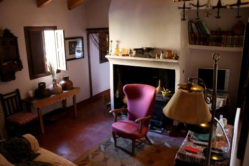 een woonkamer met een stoel en een open haard bij Casica de Perintín Cottage in Ricote