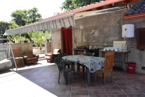 patio ze stołem i krzesłami na patio w obiekcie Angolo Verde w mieście Rometta Marea