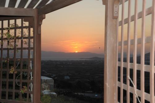 a view from a window of a sunset at Villa Kairos Naxos in Glinádhon