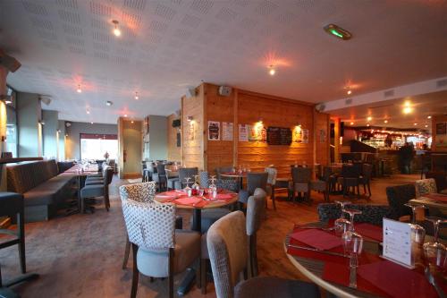 a dining room with tables and chairs in a restaurant at Hotel Rhodos Morzine in Morzine
