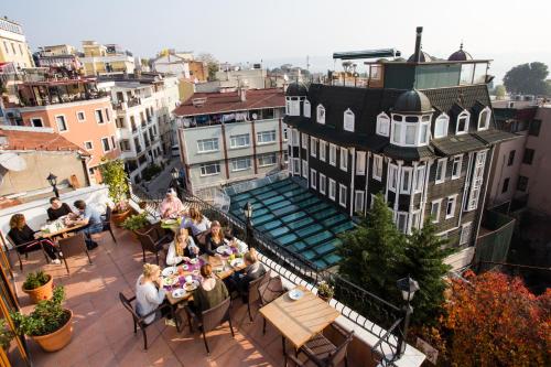 a group of people sitting at tables on a balcony at Agora Guesthouse in Istanbul