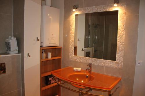 une salle de bain avec un lavabo et un miroir dans l'établissement Le Charme des Dunes, à Arcachon