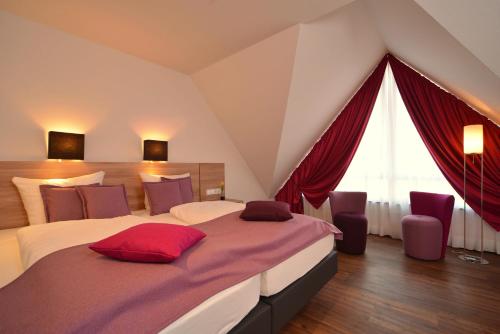 a bedroom with a large bed and red curtains at Das Crass in Nieder-Olm