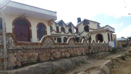 une rangée de maisons sur un mur en pierre dans l'établissement Hostal Jallalla, à Comunidad Yumani