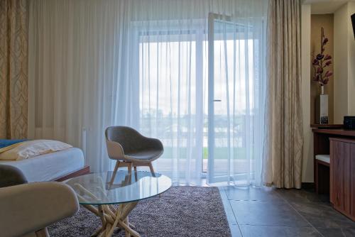 a hotel room with a chair and a glass table at Pension Laa Natura in Laa an der Thaya