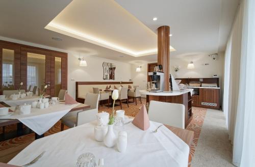 a restaurant with white tables and white chairs at Pension Laa Natura in Laa an der Thaya