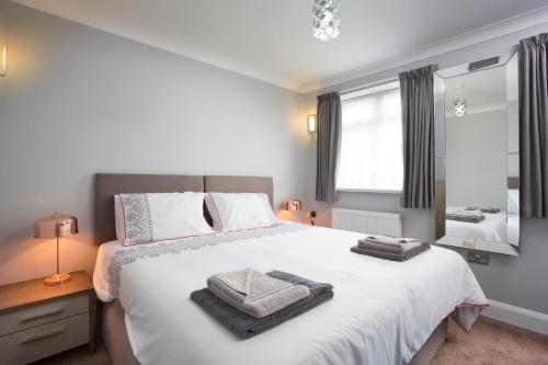 a bedroom with a large bed with towels on it at Northwood 2 in Broadstairs