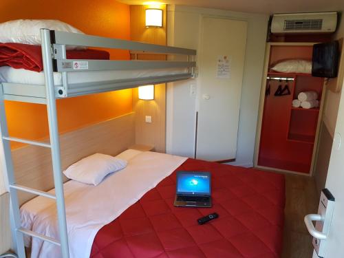 a bedroom with a bunk bed with a laptop on it at Premiere Classe Lyon Ouest - Tassin in Tassin-la-Demi-Lune