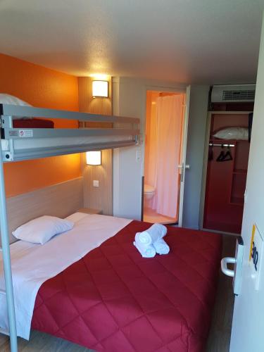 a bedroom with a bed with two towels on it at Premiere Classe Lyon Ouest - Tassin in Tassin-la-Demi-Lune