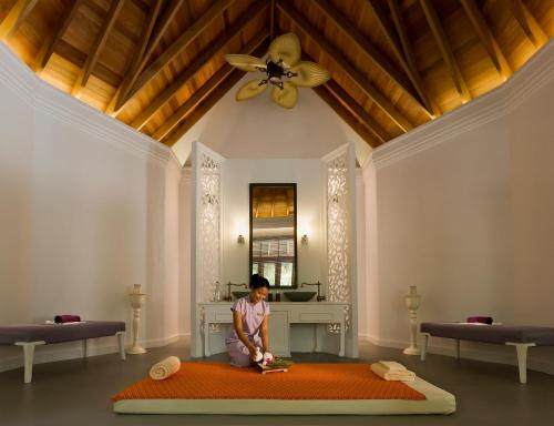 a young child standing on a bed in a room at Dusit Thani Maldives - 50 percent discount on transfers for stays until 20 Dec 2025 in Baa Atoll