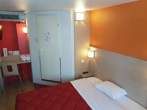 a bedroom with a bed with an orange wall at Premiere Classe Lyon Ouest - Tassin in Tassin-la-Demi-Lune