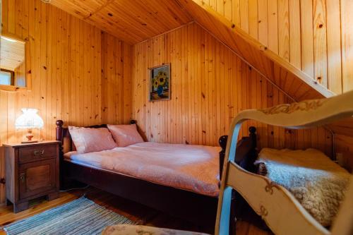 um quarto com uma cama num quarto de madeira em Domek pod bukami em Szymbark