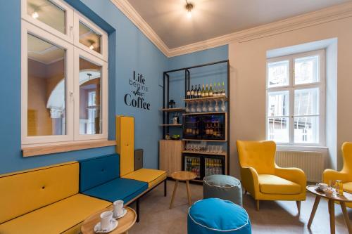 un restaurante con sillas amarillas y una pared azul en Three Corners Hotel Anna, en Budapest