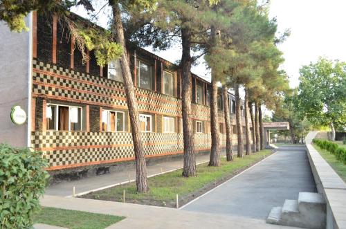a row of trees in front of a building at Evim Otel in Zaqatala