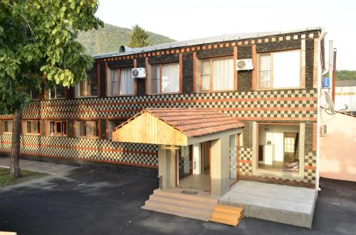 a brick building with a wooden roof on a street at Evim Otel in Zaqatala