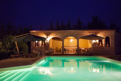 a swimming pool in front of a house at night at Casa Go'El in Chiaramonte Gulfi