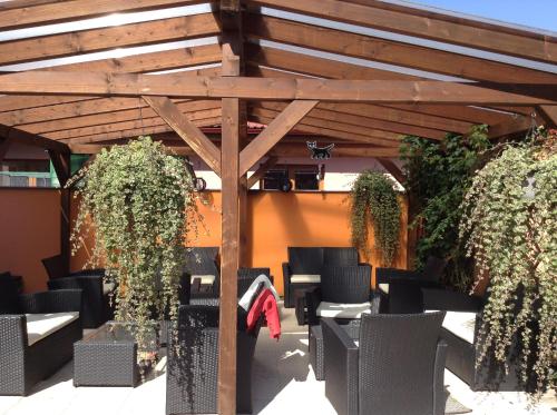 a wooden pergola with chairs and tables under it at Penzion Relax Martina in České Budějovice