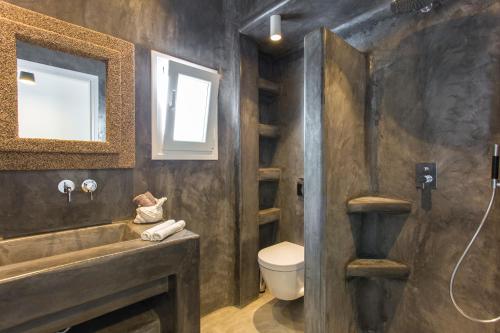 a bathroom with a sink and a toilet and a mirror at Elia Sea View Luxury Villa in Elia Beach