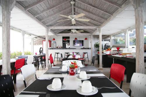 comedor con mesas y sillas y ventilador de techo en Zalmedina Hotel, en Cartagena de Indias