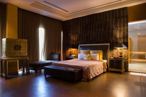 a bedroom with a king sized bed and a chair at Lu Kang Villa Spa in Lugang