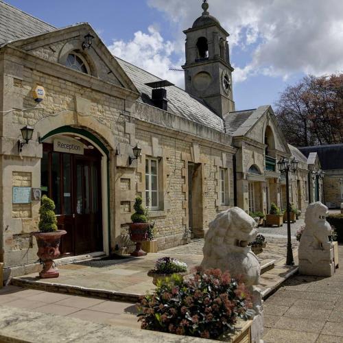an old stone building with a clock tower at Normanton Park Hotel, Sure Hotel Collection by Best Western in Oakham