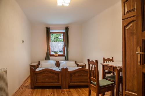 a bedroom with a bed and a table and a window at Zsirai Guest House in Mád