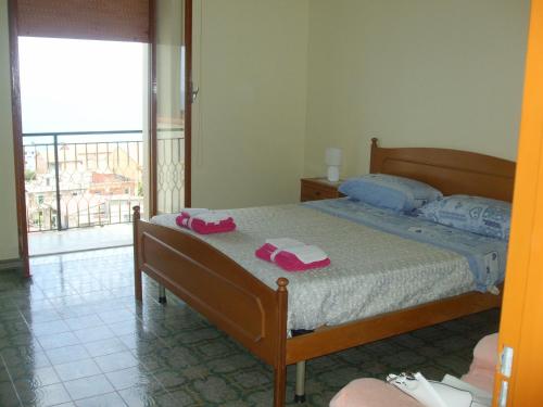 a bedroom with a bed with two pink towels on it at Villa Spaia in Brancaleone Marina