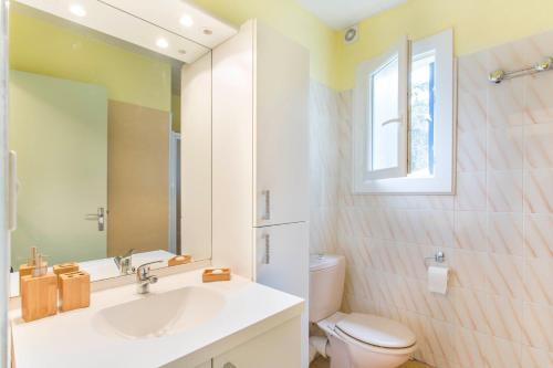 a bathroom with a sink and a toilet and a mirror at Résidence Le Mas Blanc by Popinns in Alénya