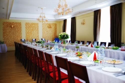 a long table with tables and chairs in a room at Lucia with Self Check-in in Ludza