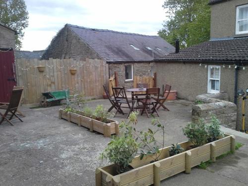 a backyard with a table and chairs and plants at Low Gingerfield Farm B&B in Richmond