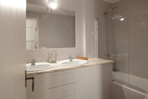 een badkamer met 2 wastafels, een spiegel en een douche bij Apartamento Mas Babu in Matajudaica