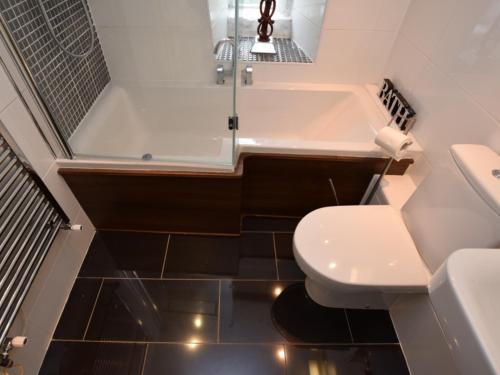 a bathroom with a tub and a toilet and a sink at White Cottage Askham in Askham