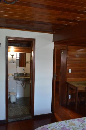 a bedroom with a door open to a bathroom at Amélia Pousada in Diamantina