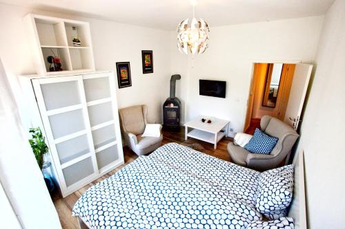 エアフルトにあるApartment Hundertwasserのベッドルーム1室(ベッド1台、ソファ、椅子付)