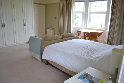 a bedroom with a bed and a couch and a table at Burnside Farm B & B in Girvan